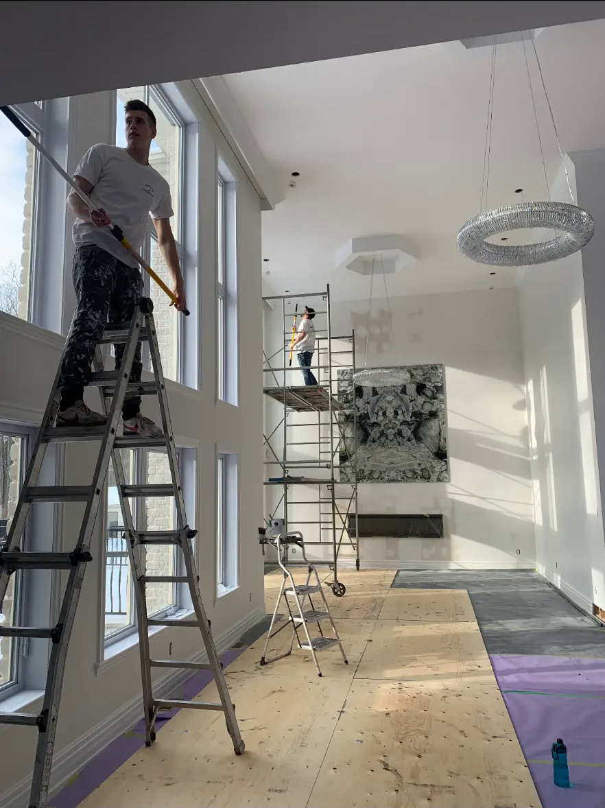 Interior painting project — crew painting a high-ceiling room before