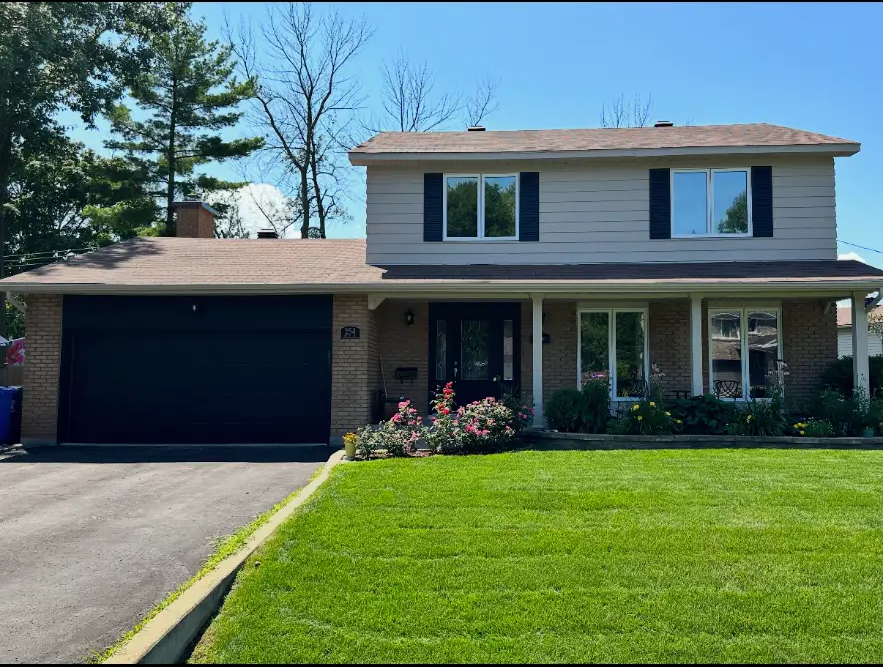Two-storey Montreal house — sprayed siding, shutters and garage door
