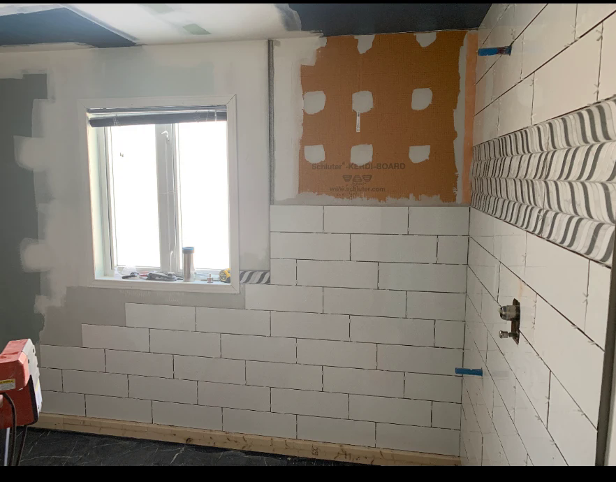 Bathroom renovation — tiling and tub install underway